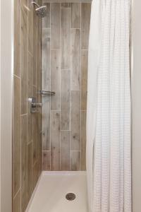 a shower with a white shower curtain in a bathroom at The Suncatcher on Gillis in Traverse City