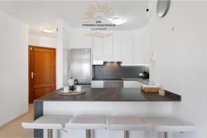 Una cocina con una encimera con taburetes. en Apartamento Oasis Tropical, en Candelaria