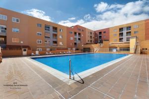 una piscina frente a un edificio en Apartamento Oasis Tropical, en Candelaria