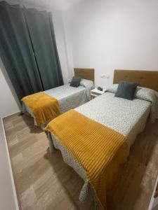 Habitación con 2 camas y mantas amarillas. en Apartamento Taymar Daniel, en Chiclana de la Frontera 24 fotos más