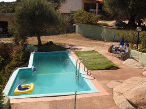 basen ze zjeżdżalnią na dziedzińcu w obiekcie Villa L'Oleandro w mieście Oliena