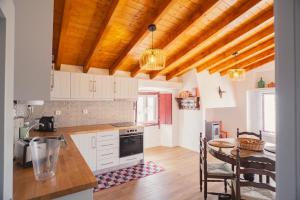 a kitchen with wooden ceilings and a table with chairs at Casa Azenha das Freiras in Borba