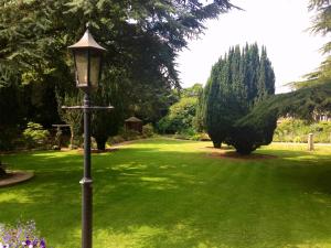 a lamp post in the middle of a green yard at The Parsonage Hotel & Spa in Escrick