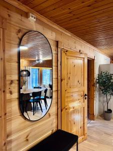 a circular mirror on the wall of a dining room at Luxurious Villa Levin Lepola - Also own private Lapland hut in Kittilä