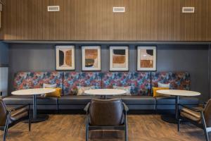 コロンバスにあるFour Points by Sheraton Columbus-Polarisのソファとテーブル2台付きの待合室