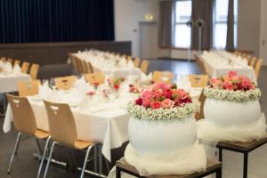 a row of tables with white tables with flowers on them at Hotel Sonne in Altstätten