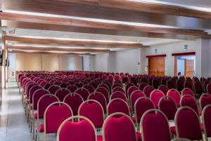 an empty room with red chairs in a building at Paradiso Corporate in Cabo Frio +116 photos