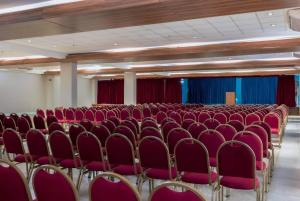 an empty room with red chairs and red curtains at Paradiso Corporate in Cabo Frio +189 photos