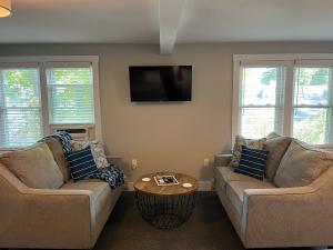 a living room with two couches and a tv at Abalonia Inn in Ogunquit