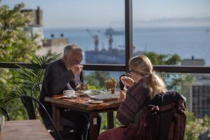 a man and a woman sitting at a table eating food at Hotel Boutique 17 in Valparaíso +73 photos