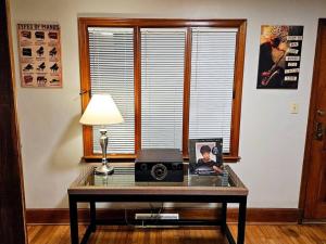 a table with a lamp and a picture on it at Charming Retreat in the heart of Burlington in Burlington