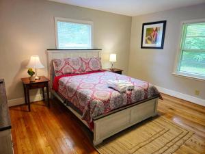 a bedroom with a bed and two tables and two windows at Charming Retreat in the heart of Burlington in Burlington +65 photos