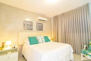 a bedroom with a white bed and a window at Flat Solar Água Bali by Qavi in Pipa