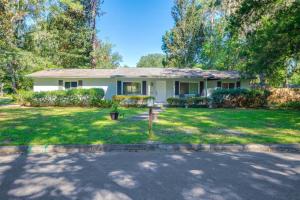 a white house with a yard with a driveway at Pet-Friendly Home - 3 Mi to University of Florida! in Gainesville