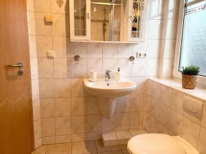 a bathroom with a sink and a toilet at Ferienhaus-Haus-Eversand in Cuxhaven +5 photos