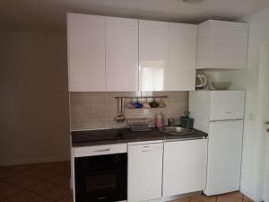 a kitchen with white cabinets and a sink and a dishwasher at Apartments Sab in Povljana