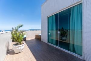 a balcony with two potted plants on a building at Paradiso Corporate in Cabo Frio