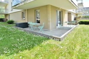 un patio con sillas y una mesa en Escapade - Appartement avec jardin et parking, en Dinan 3 fotos más