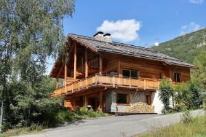 uma grande casa de madeira com uma varanda ao lado em Chalet Prestige cheminée vue excep serrechevalierholidays em Le Freyssinet