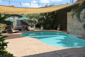 a swimming pool in a yard with a patio at Hotel León Inn in León