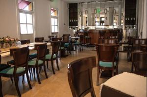 a restaurant with wooden tables and chairs and windows at Real Hotel Luján in Luján