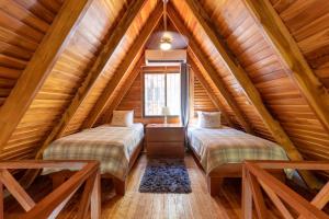 two beds in a attic bedroom with wooden ceilings at Cozy Beach Casita - 4 Min Walk to the Beach in Nosara +5 photos