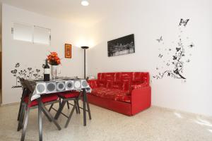 ein Wohnzimmer mit einem roten Sofa und einem Tisch in der Unterkunft Albatros Beach Club in Benalmádena