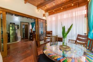 a dining room with a glass table and chairs at Namaste Beach Bungalow 1 BDR Loft 4 Min to Beach in Nosara
