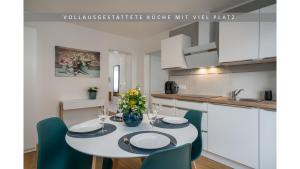 a kitchen with a table and chairs in a kitchen at Apartment Leinetal mit Kamin, Seenähe, Terrasse in Northeim +5 photos
