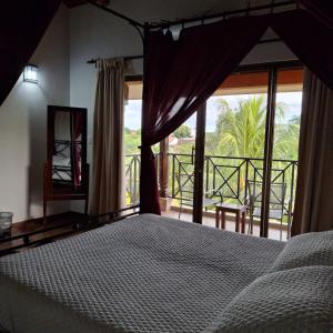 a bedroom with a bed with a view of a balcony at Hotel Jardín Garden de Granada Nicaragua in Granada +17 photos