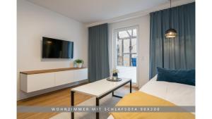 a room with a bed and a tv and a table at Apartment Leinetal mit Kamin, Seenähe, Terrasse in Northeim