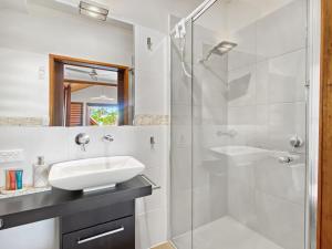 a white bathroom with a sink and a shower at Pure Magnetic Villa 10 in Nelly Bay +23 photos