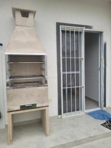 a dresser sitting next to a door with a gate at Casa nova em Caraguatatuba in Caraguatatuba