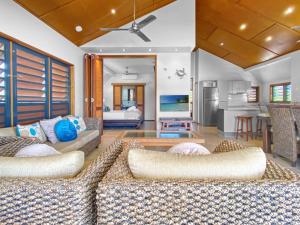 a living room with two couches and a kitchen at Pure Magnetic Villa 10 in Nelly Bay