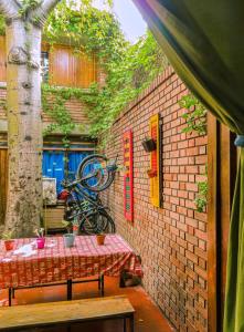 a table with a bike parked next to a brick wall at OlasHostel in Mendoza