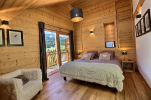 um quarto com uma cama num chalé de madeira em Chalet Prestige cheminée vue excep serrechevalierholidays em Le Freyssinet