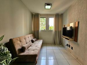 un salon avec un canapé et une télévision dans l'établissement Apt 402 com 3 quartos 10min Paraguai e 5min centro, à Foz do Iguaçu
