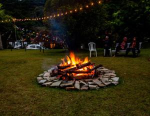a fire pit in a yard with people sitting around at Casa na Serra para 14 Pessoas com Piscina e Churrasqueira - Da Francesa in Bom Jardim