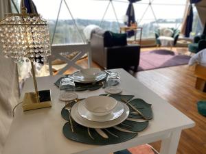 a table with plates and utensils on top of it at FéLIZA Rainforest Domes in Monteverde Costa Rica