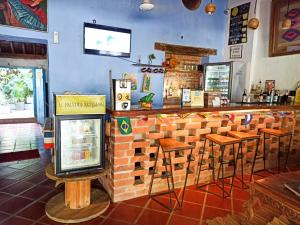 a bar in a restaurant with a brick wall and stools at Hostel Pueblito Magico Mompós in Santa Cruz de Mompox