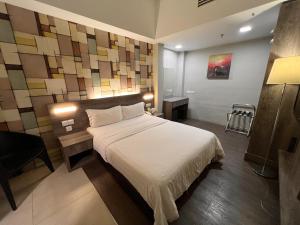 Ένα ή περισσότερα κρεβάτια σε δωμάτιο στο Ajang Hotel