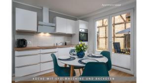 a kitchen with a table and chairs in a kitchen at Apartment Leinetal mit Kamin, Seenähe, Terrasse in Northeim