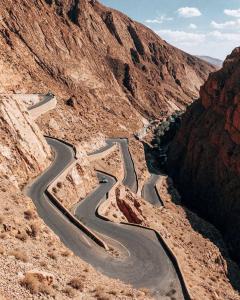 a winding road in a canyon in the desert at Hôtel Riad Atlas Dades in Boumalne +28 photos