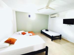 a bedroom with two beds and a flat screen tv at Laurel plaza 46 in Montería