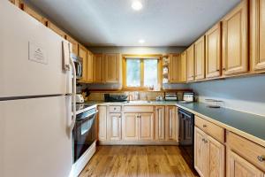Una cocina con gabinetes de madera y un refrigerador blanco. en Mountain Memories, en Bartlett