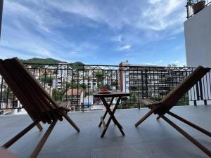 a balcony with two chairs and a table on a balcony at Cómodo Apartamento zona Romántica con alberca 503 in Puerto Vallarta