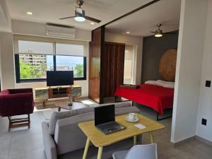 a living room with a couch and a laptop on a table at Cómodo Apartamento zona Romántica con alberca 503 in Puerto Vallarta