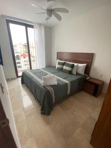a bedroom with a large bed with a ceiling fan at Francisca Luxury Suites - Adults Only in Puerto Vallarta +23 photos