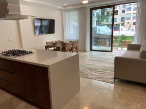 a kitchen with a stove and a living room at Francisca Luxury Suites - Adults Only in Puerto Vallarta