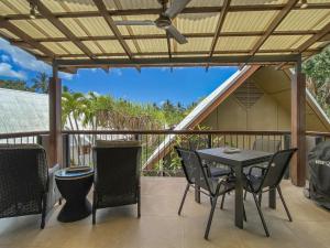 a patio with a table and chairs on a balcony at Pure Magnetic Villa 10 in Nelly Bay